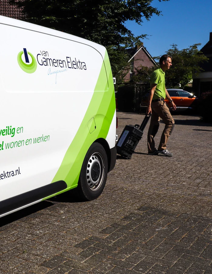 Mark van Gameren loopt met zijn gereedschapskoffer naar zijn bedrijfsbus in een woonstraat